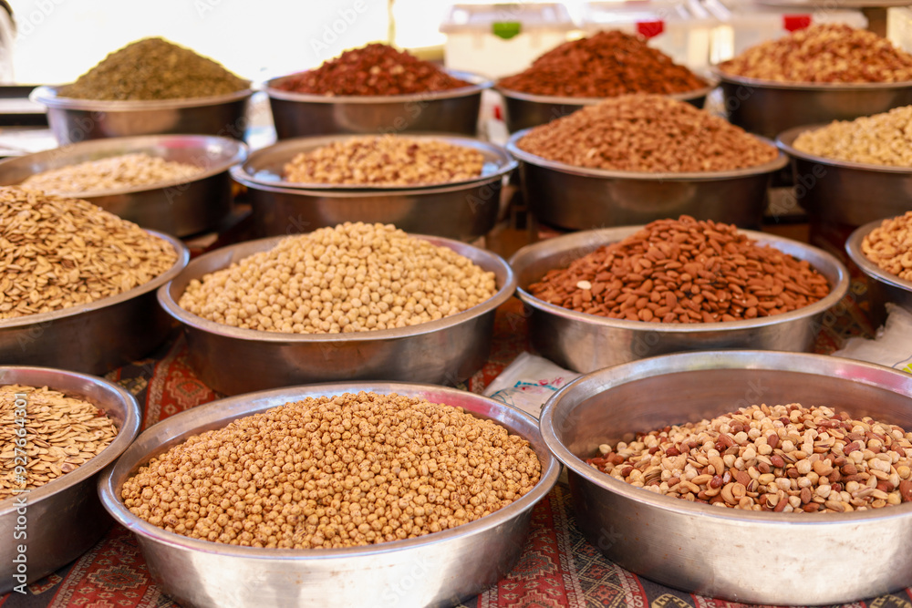 Many different nuts in large metal vices on the counter of a local bazaar Many different nuts in large metal vices on the counter of a local bazaar