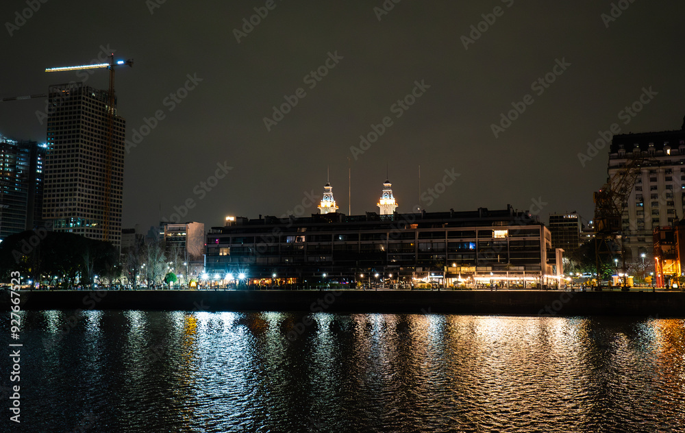 Fototapeta premium city skyline at night with a river running through it