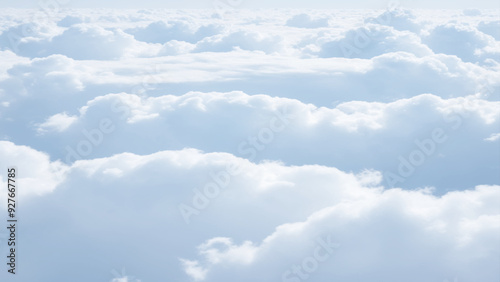 White Clouds from above. Aerial view of the fluffy white cloud on blue sky. Top view from an airplane over white clouds in a blue sky. High in the Heavens.