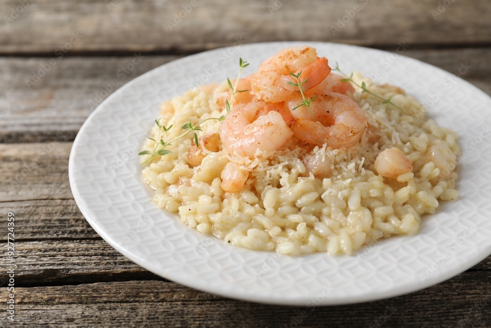 Delicious risotto with shrimps and cheese on wooden table, closeup Delicious risotto with shrimps and cheese on wooden table, closeup