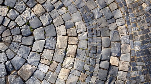 Pavement and street laid with grey paving stones in semi circular pattern