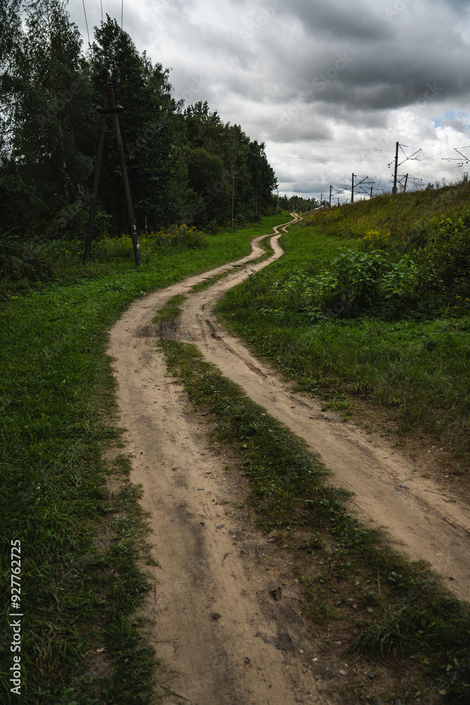 A rural, dirt road leading up. Cloudy sky A rural, dirt road leading up. Cloudy sky