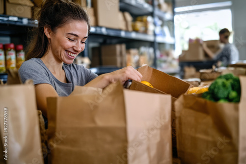 Young woman smiling while packing groceries in a food bank warehouse