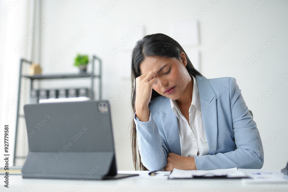 Businesswoman having a headache and feeling tired from working on a laptop for a long time