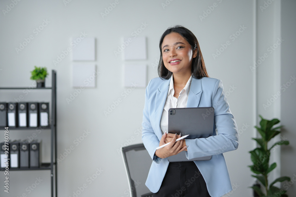 Successful asian businesswoman holding digital tablet and stylus pen standing in her office Successful asian businesswoman holding digital tablet and stylus pen standing in her office