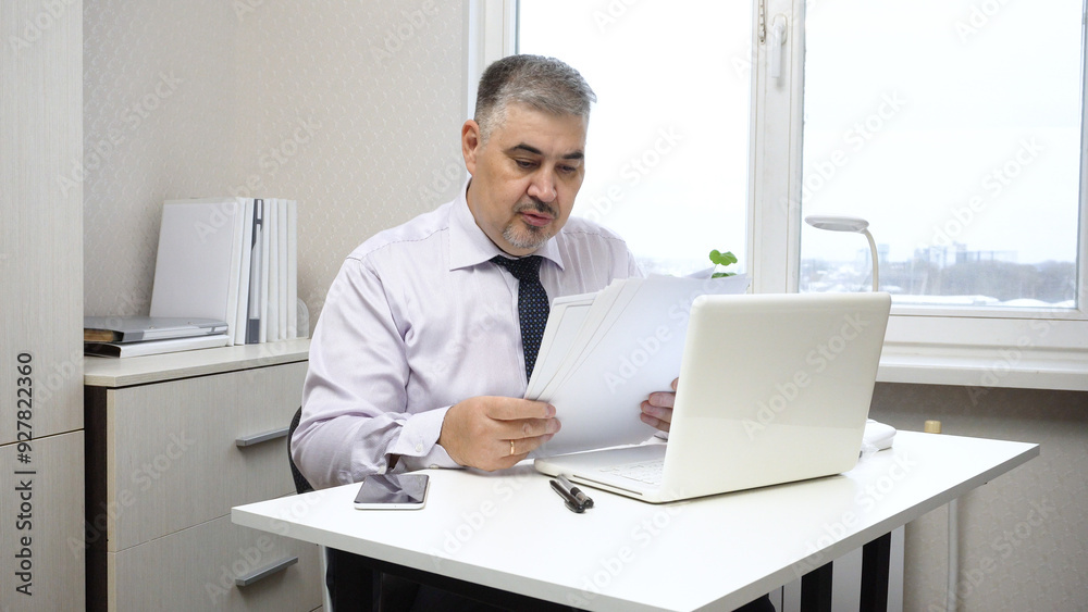Businessman at Desk in Office Working with Documents