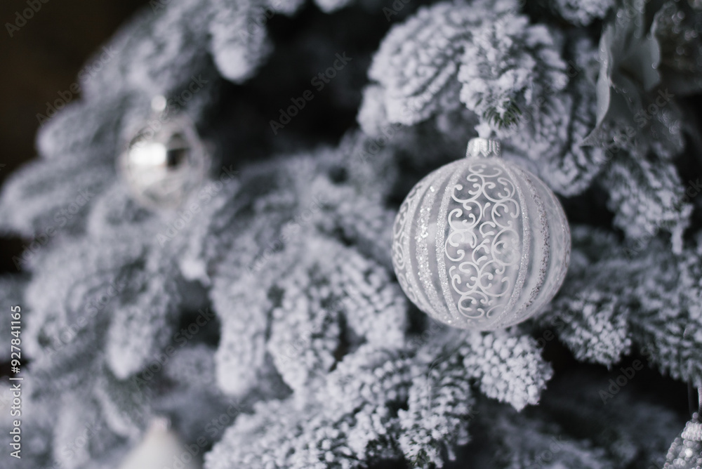 White ornament hangs on christmas tree with snow on it White ornament hangs on christmas tree with snow on it