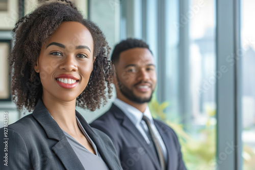 Smiling business man and woman of different races indoors