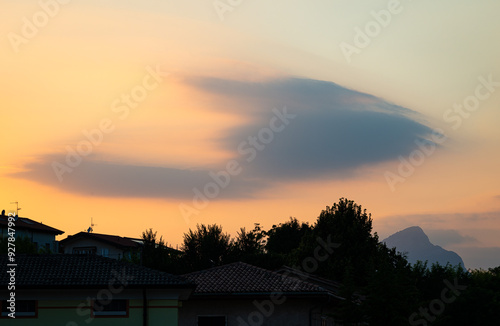 Lens-shaped clouds (Altocumulus lenticularis) over the Italian Alps during sunset photo