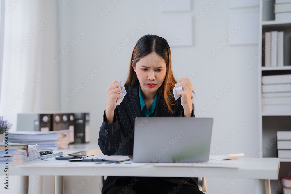 Frustration at the Desk: A businesswoman sits at her desk, overwhelmed with paperwork and struggling to manage her workload. The image captures the raw emotion of frustration and the pressure of deadl Frustration at the Desk: A businesswoman sits at her desk, overwhelmed with paperwork and struggling to manage her workload. The image captures the raw emotion of frustration and the pressure of deadl