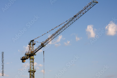 Fotografía Tower Crane at Industrial Construction Site Against Blue Sky, Steel Structure an