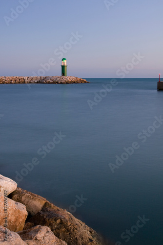 Photography Lighthouse on the Rocky Coast with Ocean Waves, Harbor, Ships and Dramatic Sunse