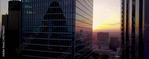 
As the sun begins to set over London, the city's iconic skyline is bathed in a warm, golden glow. From a drone's aerial perspective, the skyscrapers rise majestically, their glass facades reflecting 
