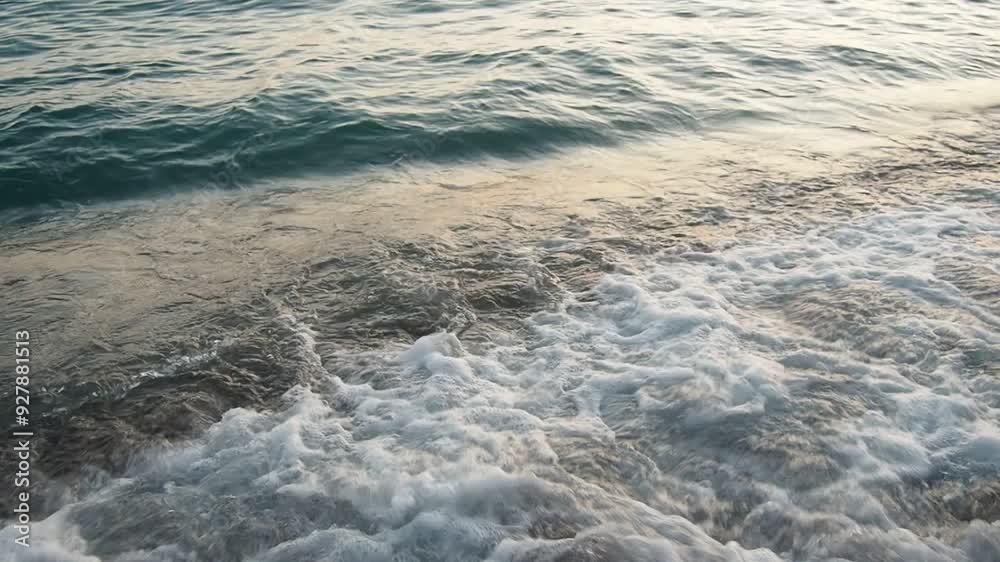 Waves gently lap at shore during stunning sunset over ocean. Golden sunlight reflects off waves as they roll onto shore, creating tranquil atmosphere at sunset by sea. Montenegro summer Canj Waves gently lap at shore during stunning sunset over ocean. Golden sunlight reflects off waves as they roll onto shore, creating tranquil atmosphere at sunset by sea. Montenegro summer Canj