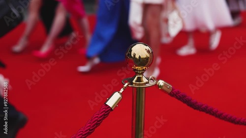 Red carpet with ropes and golden barriers on a luxury party entrance, cinema premiere film festival event award gala ceremony, wealthy rich guests arriving, outdoor decoration elements, summer day