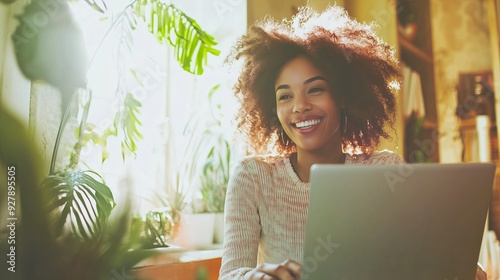 Giovane donna afroamericana lavora con passione al laptop, circondata da piante in un ambiente luminoso e accogliente. Rappresenta il concetto di equilibrio tra natura e tecnologia. photo