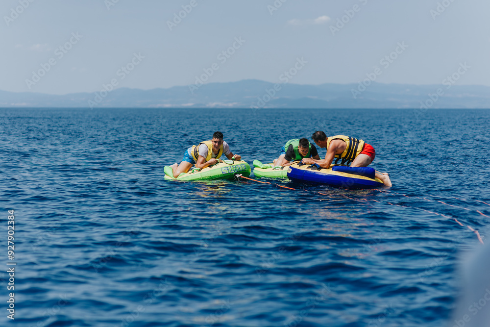 Friends enjoying a thrilling speedboat tubing adventure on a sunny day Friends enjoying a thrilling speedboat tubing adventure on a sunny day