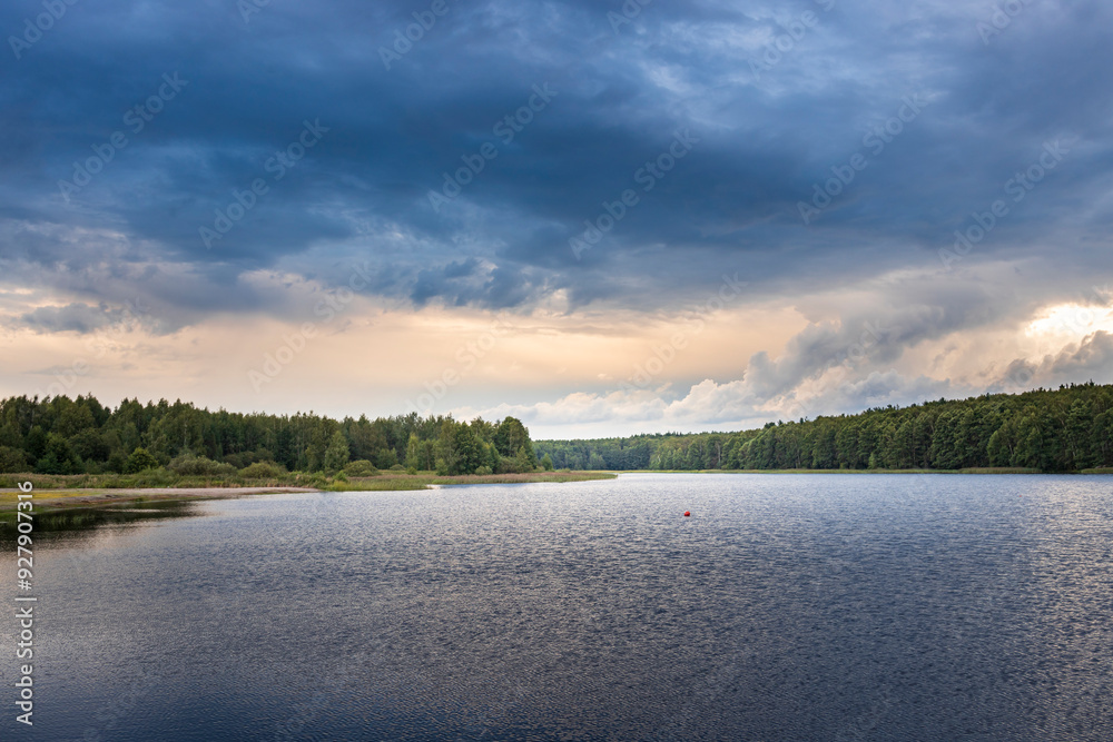 Fototapeta premium A lake with a cloudy sky in the background