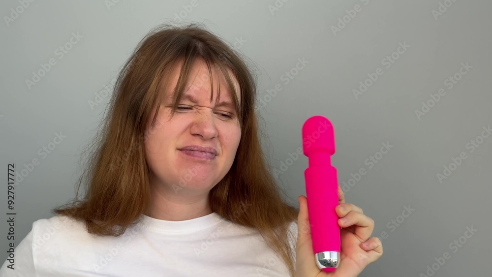 Confused young woman with sex toy for adults, female with vibrator Confused young woman with sex toy for adults, female with vibrator