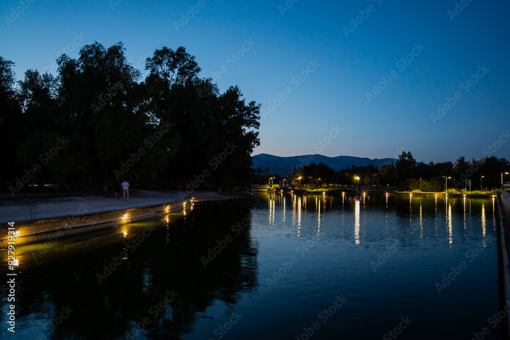 Fototapeta premium Evening lanterns as reflection in park in greece. quite evening with calm lights 