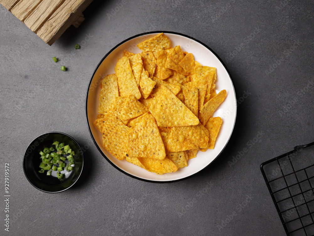 Savory salted corn chips on a plate with a plain background Savory salted corn chips on a plate with a plain background