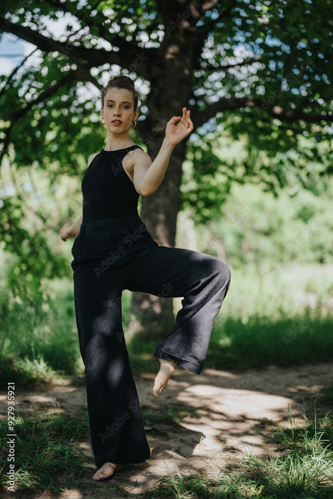 A young girl performing a graceful modern dance move in nature, surrounded by lush greenery and natural light. A young girl performing a graceful modern dance move in nature, surrounded by lush greenery and natural light.