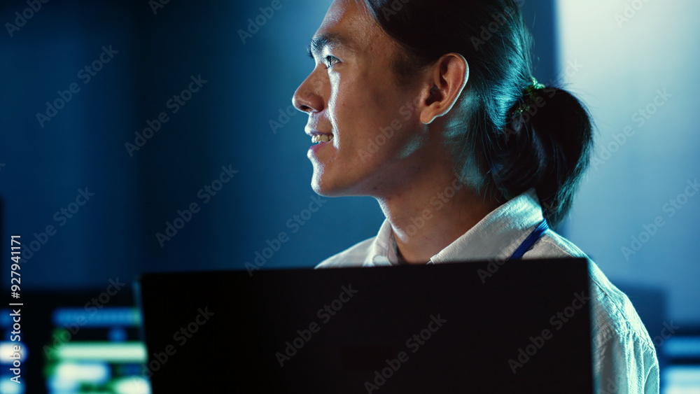 Close up shot of happy employee wandering around data center infrastructure providing processing resources for different workloads. Smiling admin doing analysis on servers Close up shot of happy employee wandering around data center infrastructure providing processing resources for different workloads. Smiling admin doing analysis on servers