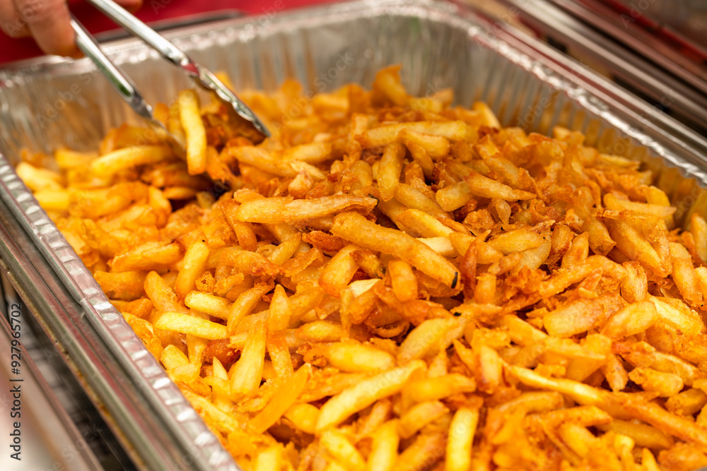 Party bowl with french fries. Tongs grabbing french fries. Party bowl with french fries. Tongs grabbing french fries.