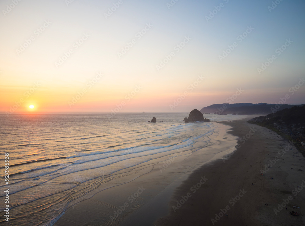 The ocean is calm and the sun is setting, creating a beautiful The ocean is calm and the sun is setting, creating a beautiful