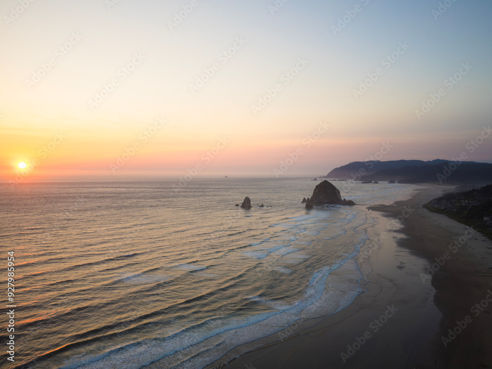Obraz premium The ocean is calm and the sky is a beautiful orange color