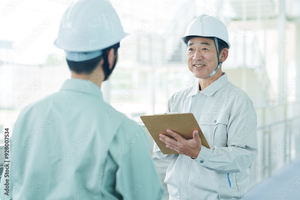 現場で打ち合わせをする作業員 現場で打ち合わせをする作業員