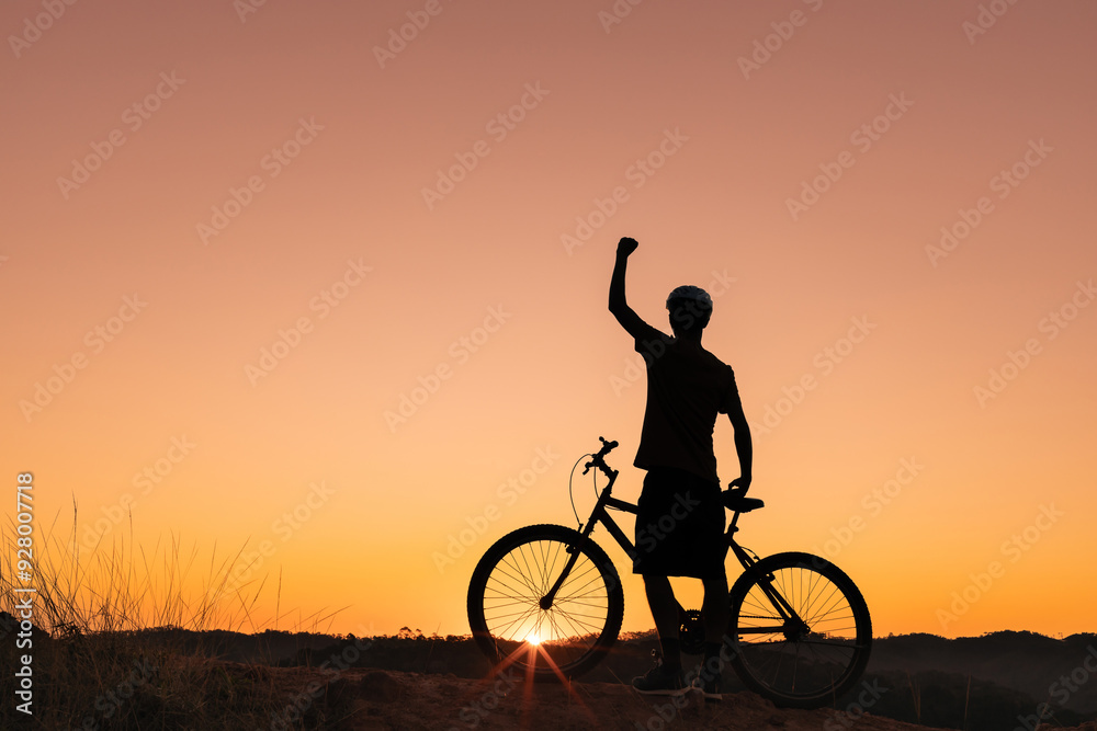 Determined and happy cyclist celebrates at sunset. Symbolizing achievement, freedom, and joy in nature's beauty. Ideal for themes of fitness, motivation, and outdoor adventure. Determined and happy cyclist celebrates at sunset. Symbolizing achievement, freedom, and joy in nature's beauty. Ideal for themes of fitness, motivation, and outdoor adventure.
