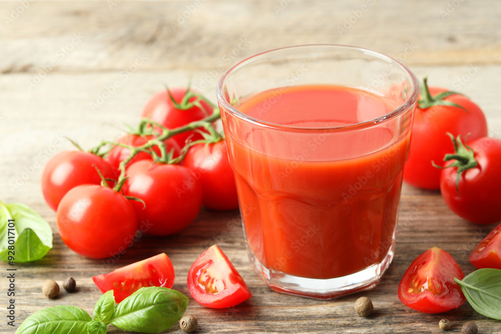 Tasty tomato juice in glass with fresh vegetables and spices on wooden table, closeup Tasty tomato juice in glass with fresh vegetables and spices on wooden table, closeup