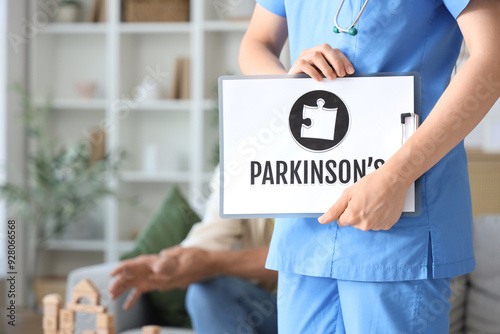 Nurse holding clipboard with word PARKINSON'S at home, closeup