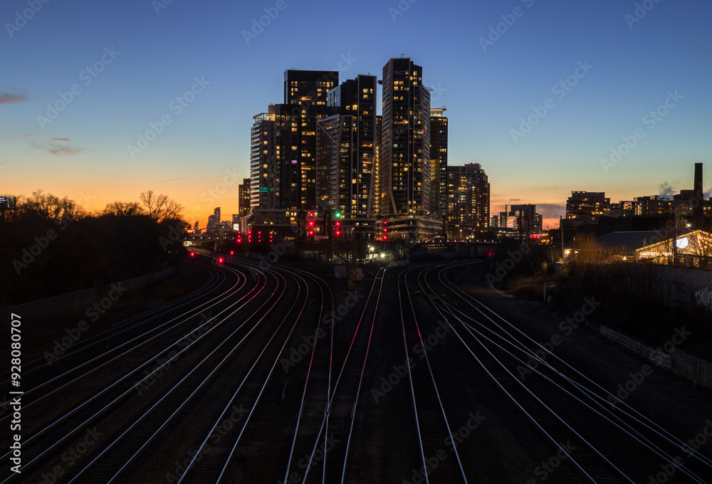 Fototapeta premium Downtown city at night. Sunset in financial district. railway interchange, condos, office buildings illuminated. skyline Toronto, Ontario, Canada