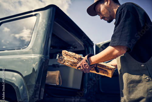 車から薪を取り出す男性