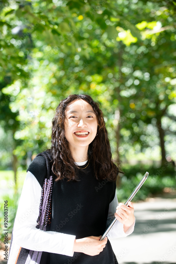 ファイルを持ってこちらを見ている大学生 ファイルを持ってこちらを見ている大学生