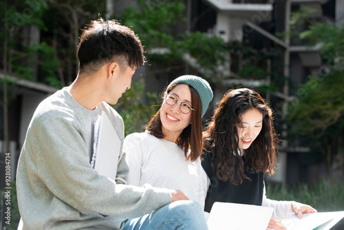 ファイルを広げて話している学生3人 photo