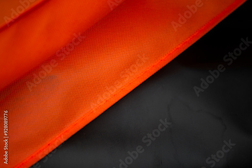 Red and black silk fabric on black background. Textile industry.