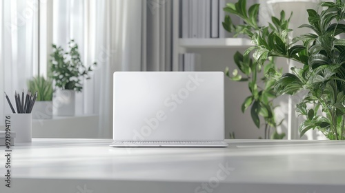 White Laptop on Minimalist Desk with Green Plants and Natural Light.