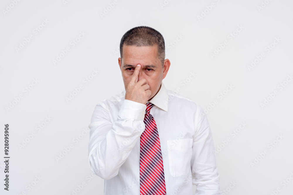 A restless middle aged asian manager fidgeting his glabella, coping with a stressful day. Isolated on a white background. A restless middle aged asian manager fidgeting his glabella, coping with a stressful day. Isolated on a white background.