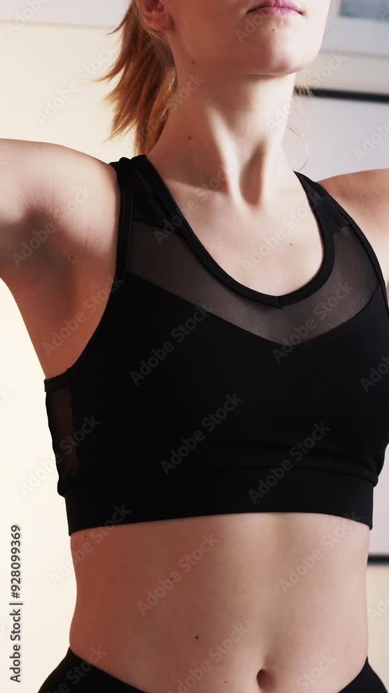 Vertical video. Warmup exercise. Fitness workout. Sport instructor. Healthy activity. Fit woman in sportswear rotating arms at light room indoors. Vertical video. Warmup exercise. Fitness workout. Sport instructor. Healthy activity. Fit woman in sportswear rotating arms at light room indoors.