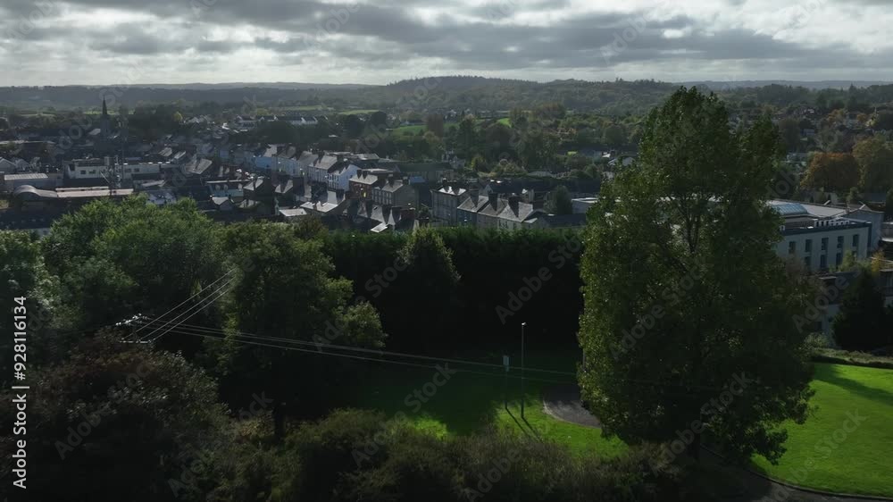 Carrickmacross Town, County Monaghan, Ireland, November 2022. Drone pushes towards the town tilting down revealing the old buildings with cars driving along main street.