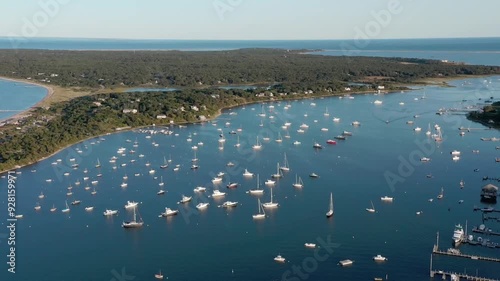 An aerial parallax shot of sailboats moored off Chappaquiddick Island in Martha's Vineyard, Massachusetts photo