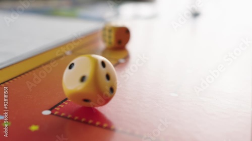 The hand throws yellow dices on the playing field. Gaming moments in dynamics. Luck and excitement. Board games strategy. Slow motion.