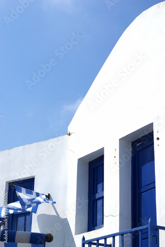 Greece's flag on a traditional whitebuilding on a summer day photo