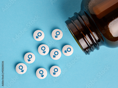 Medical hormone pills with male symbol spilling out of the bottle. photo