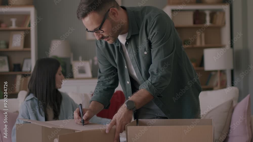 A couple is preparing their old clothes and packing them in the box to share with those in need A couple is preparing their old clothes and packing them in the box to share with those in need