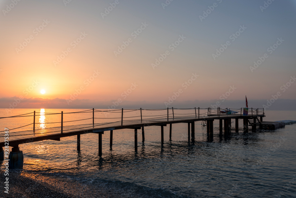 A wooden pier with a red umbrella on it A wooden pier with a red umbrella on it