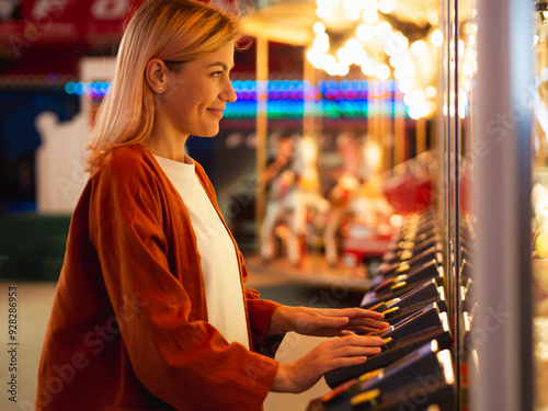 Girl having fun at amusement park. Night fair illumination